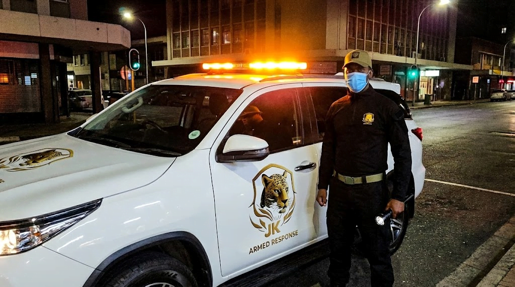 Armed response security vehicle with flashing lights patrolling residential area at night